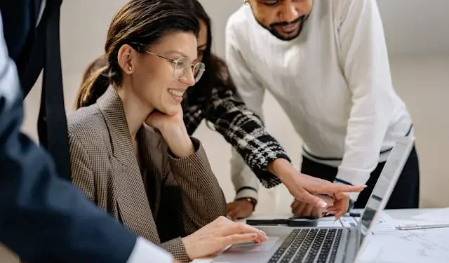 Team discussing product reviews on a laptop