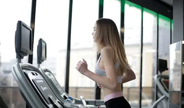 Woman jogging on a treadmill in a modern gym